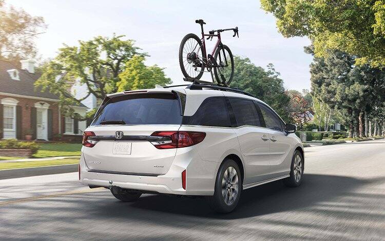 2026 Honda Elite in Platinum White Pearl driving through residential  neighborhood. 